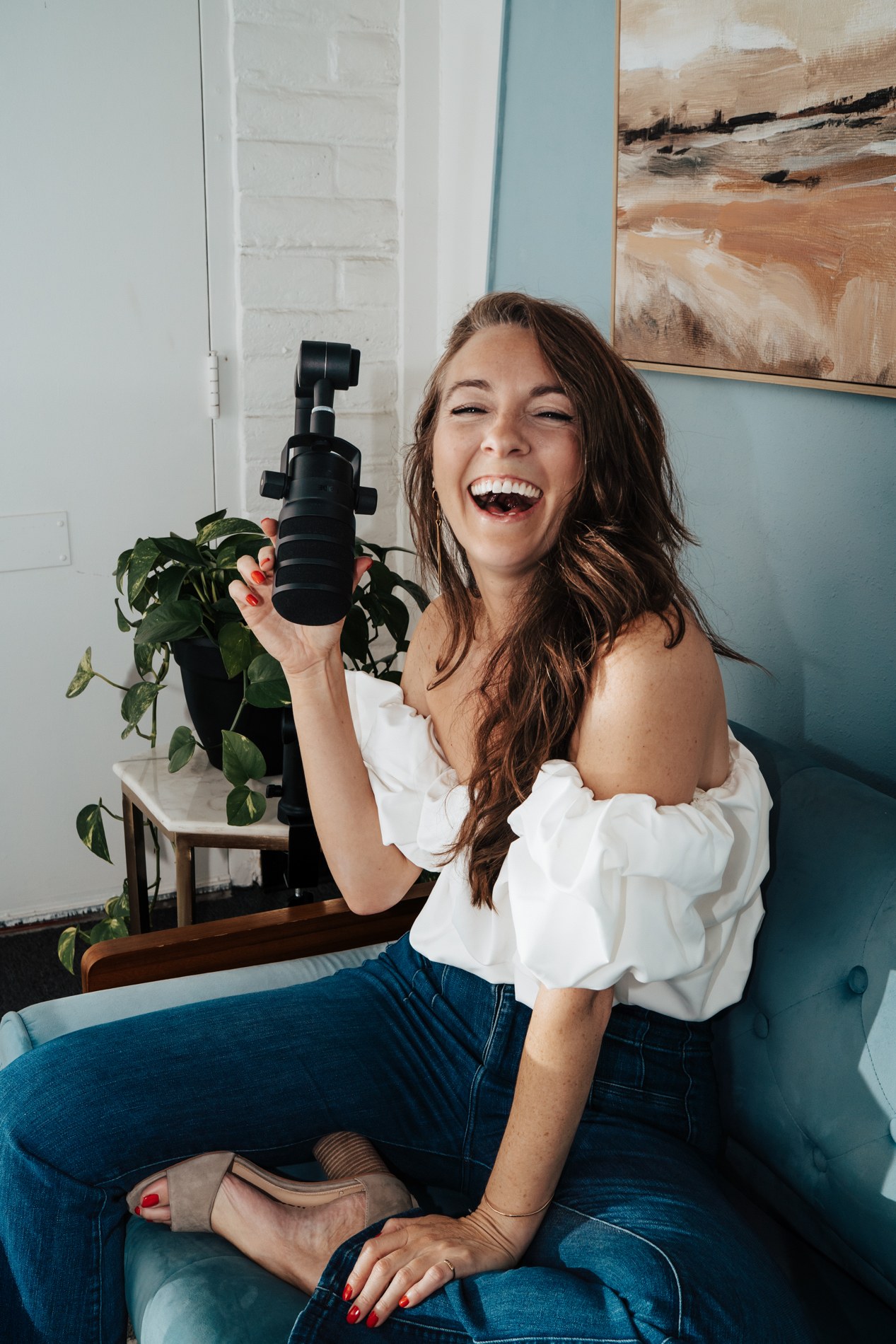 Kimberly smiling beside a podcast microphone